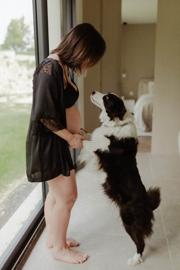 femme enceinte qui tient son chien par les pattes